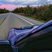 Blue 2018 Dodge Charger SRT Hellcat driving along road with trees changing color