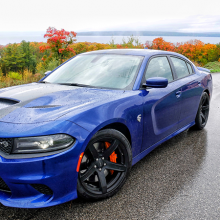 Blue 2018 Dodge Charger SRT Hellcat parked on street with trees changing color in the background