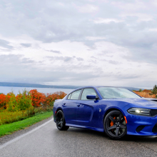 Blue 2018 Dodge Charger SRT Hellcat parked on street with trees changing color in the background