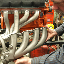 Man holding up cast iron exhaust manifold