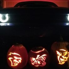 Dodge Hellcat, Angry Bee and Dodge Demon pumpkin in front of the front end of a Dodge Demon