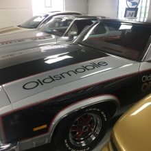 Oldsmobile's lined up in a garage