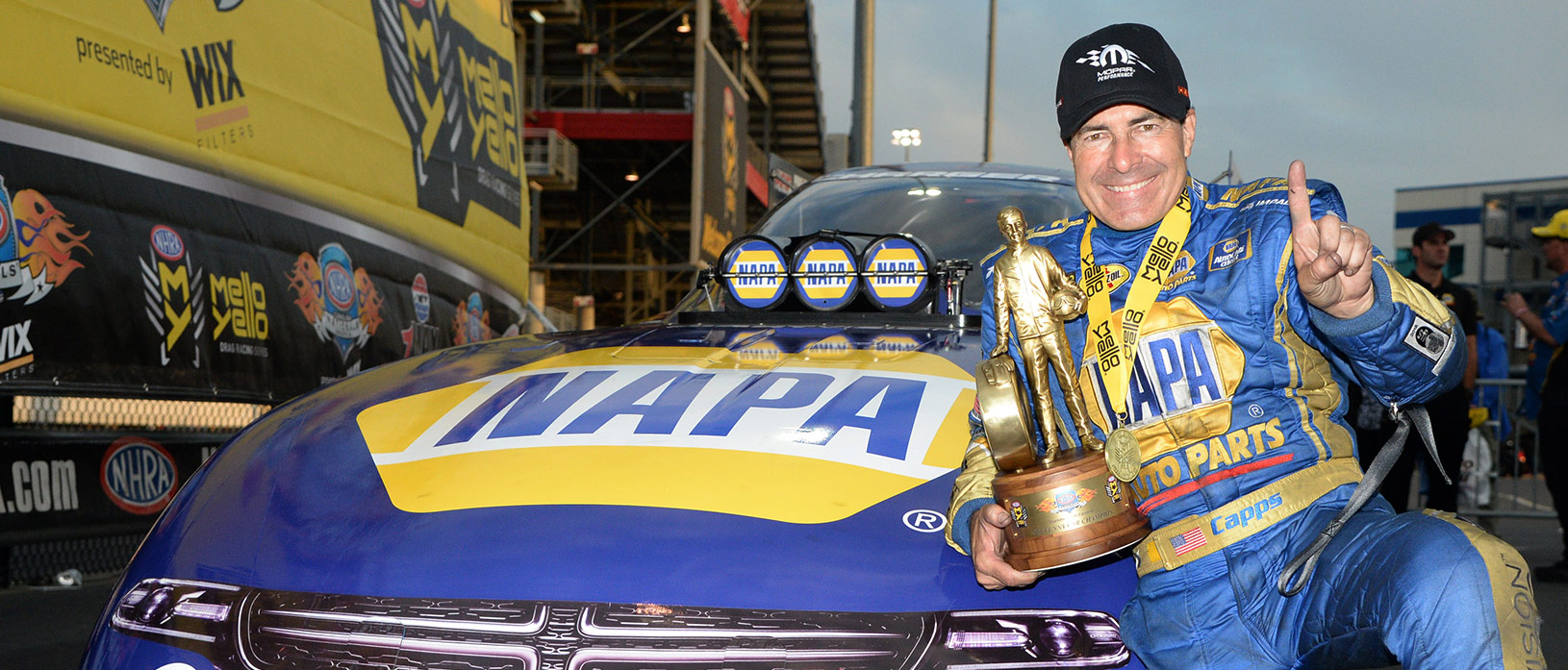 Ron Capps poses with his trophy next to his Napa Auto Parts Top Fuel Dragster race car