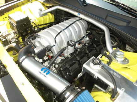 Adorned with a Mopar Performance cold air kit and strut tower brace, the original 6.1-liter HEMI® was bored and stroked to a full 426 cubes. The fabricated Moroso coolant reservoir adds drag strip pit vibes.