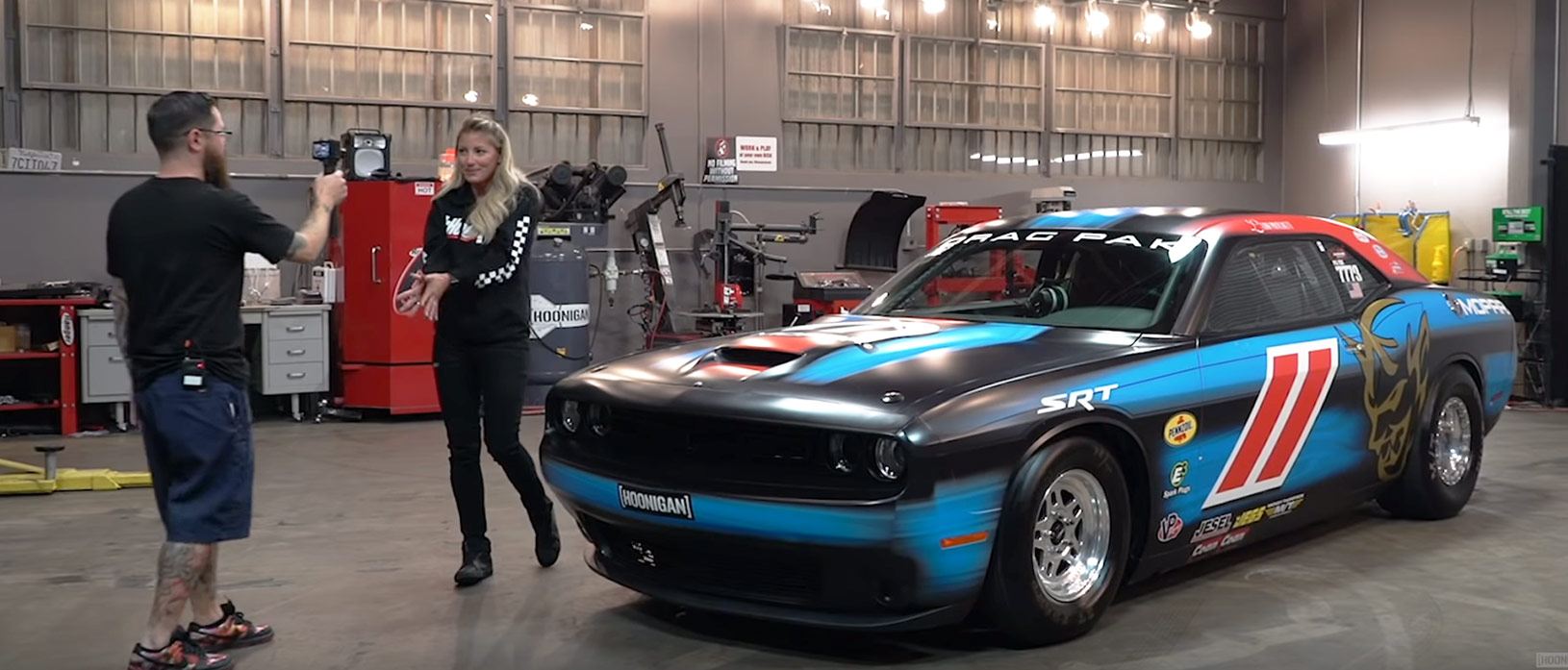 Leah standing in front of her Dodge Mopar Challenger Drag Pak while Hoonigan films