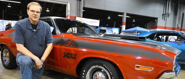 Brad Schroeder kneeling in front of 1970 Challenger T/A