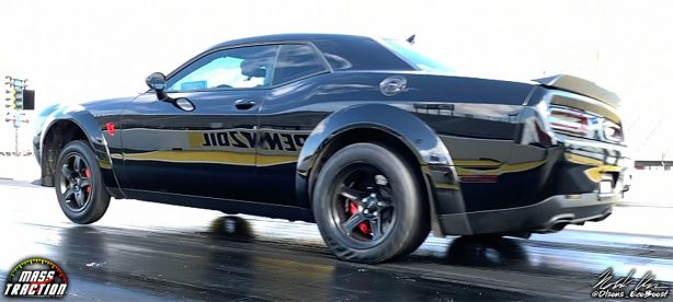 Black Dodge Demon racing down the track