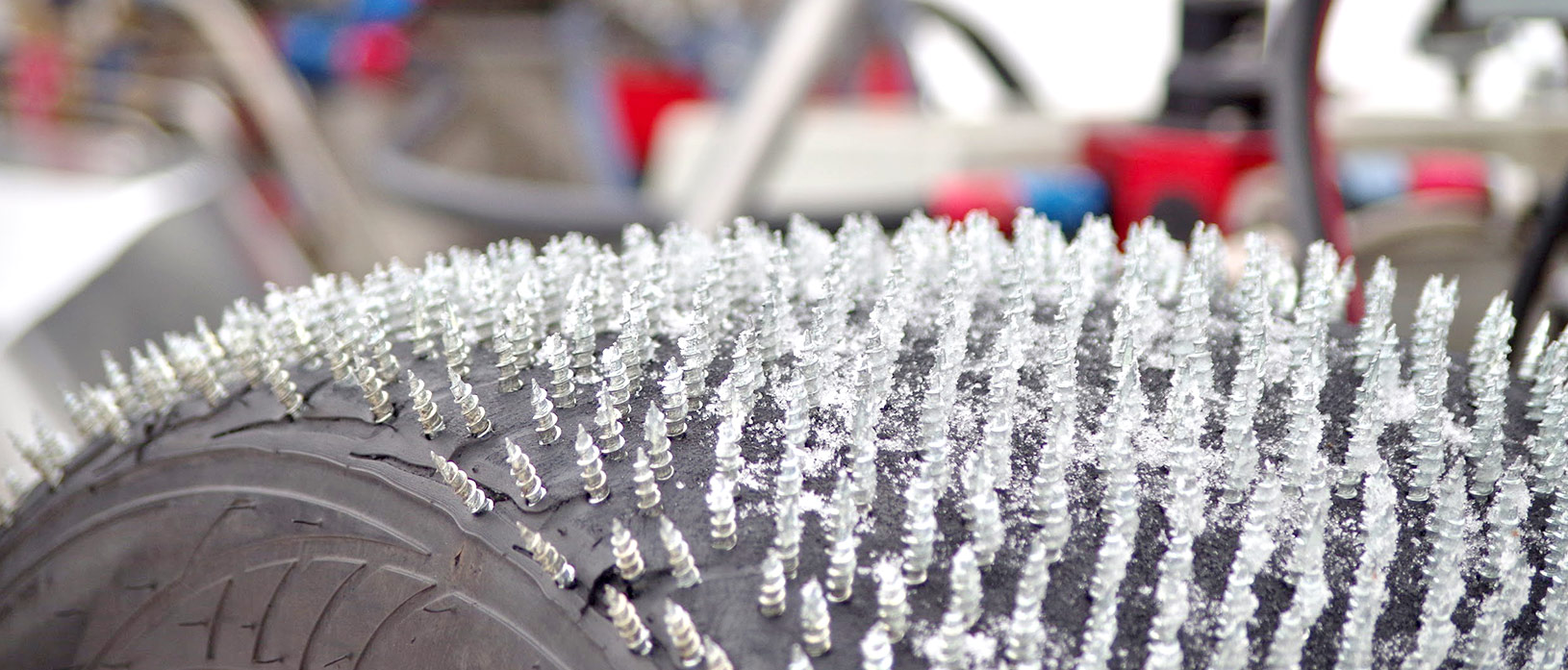 Close up of screws drilled throughout tire making an ice drag radial