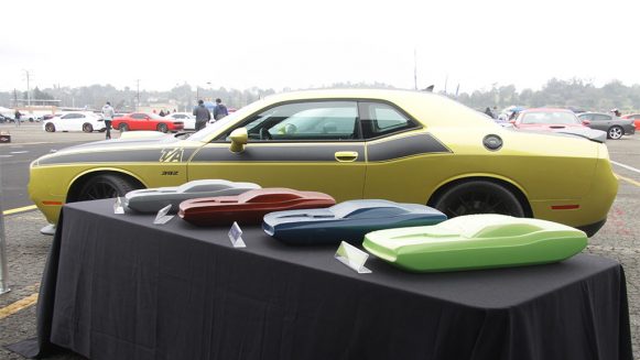 Yellow Dodge Challenger T/A with color forms in different colors in front of the car