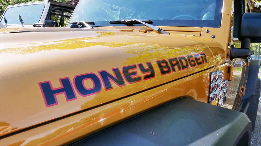 Yellow Jeep with the graphic "Honey Badger"