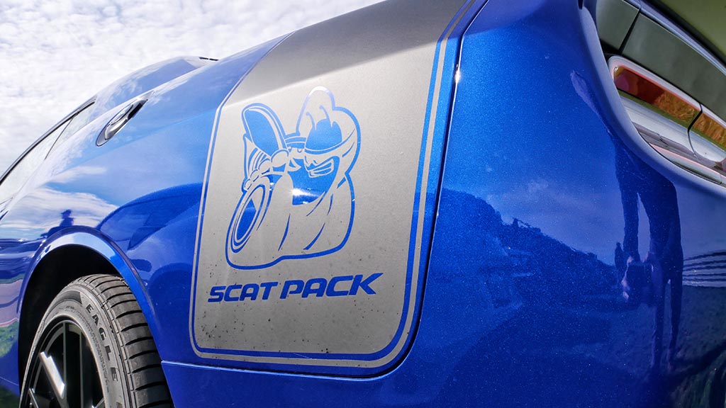 Rear end of blue Dodge Challenger scat Pack with the scat pack angry bee logo