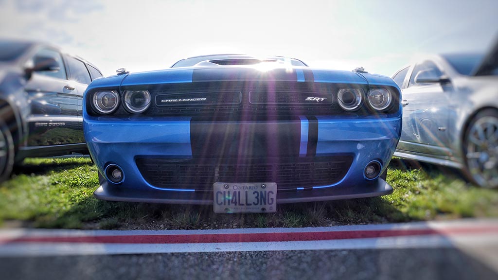 Front end of blue Dodge Challenger SRT with matte black racing stripe