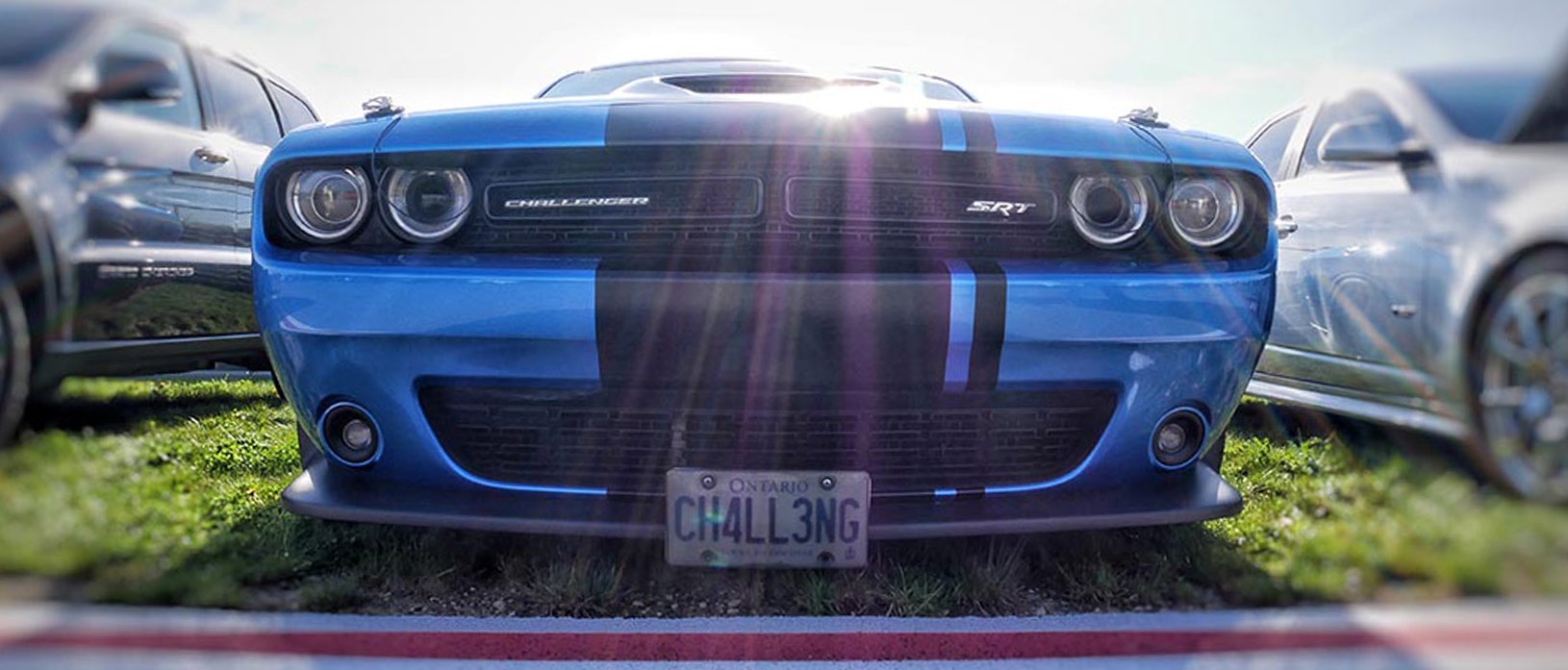 Front of blue Challenger SRT Hellcat with black center stripe