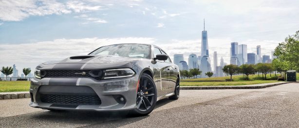 a gray dodge charger with the new york city skyline in the background