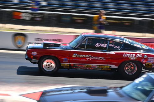 red vehicle on the starting line of a drag strip