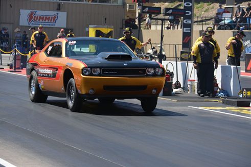 orange vehicle on the starting line of a drag strip