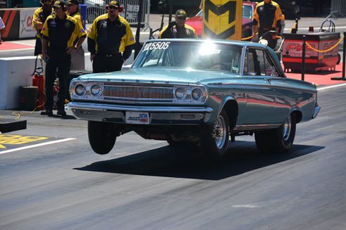 blue vehicle driving on its two back wheels