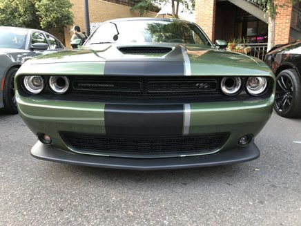 green vehicle with a thick black stripe on the hood