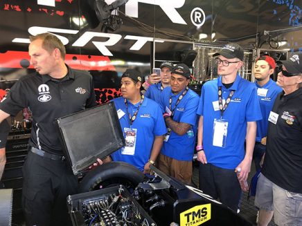 students getting a tour around a vehicle