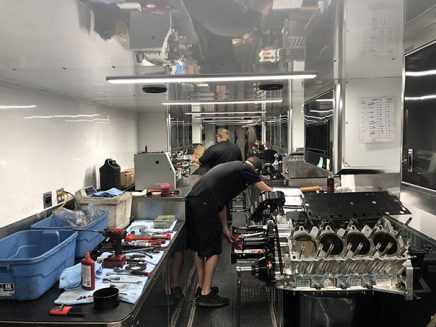 crew members using tools and vehicle parts in cruz pedregon's trailer