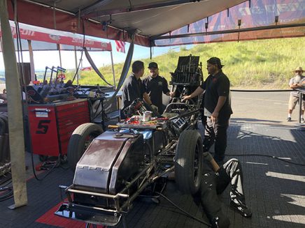 crew members working on cruz pedregon's funny car