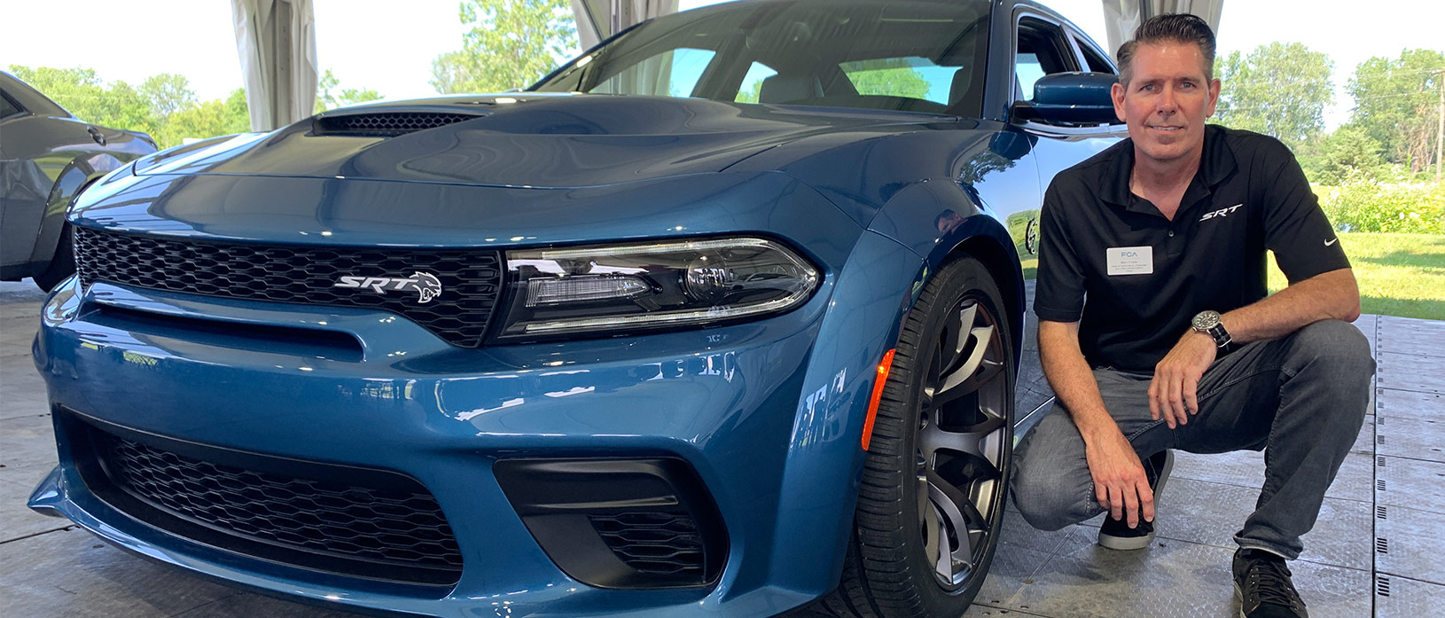 man kneeling next to a 2020 Charger Hellcat Widebody