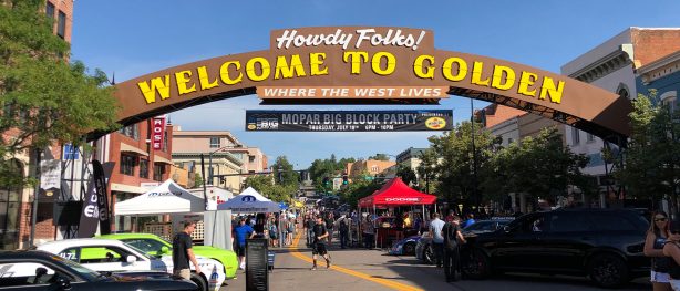 street with a welcome sign filled with people