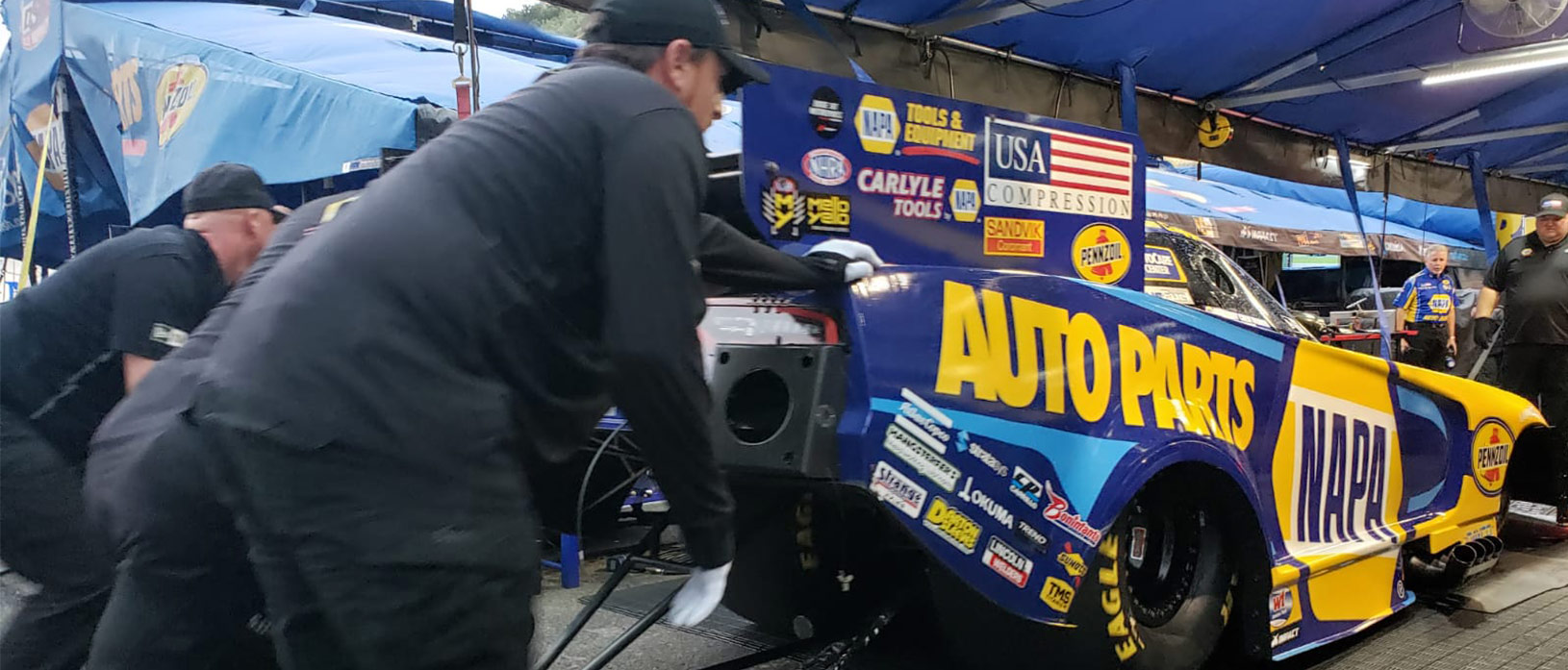 crew members pushing ron capps' funny car