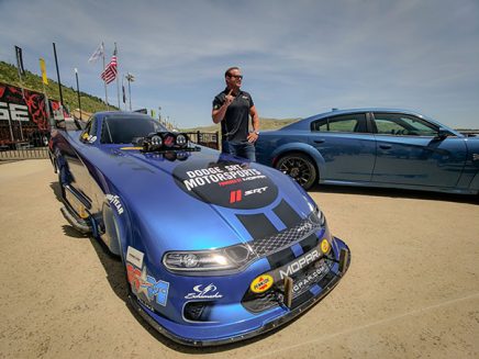 matt hagan standing next to his 2020 dodge charger srt hellcat widebody funny car