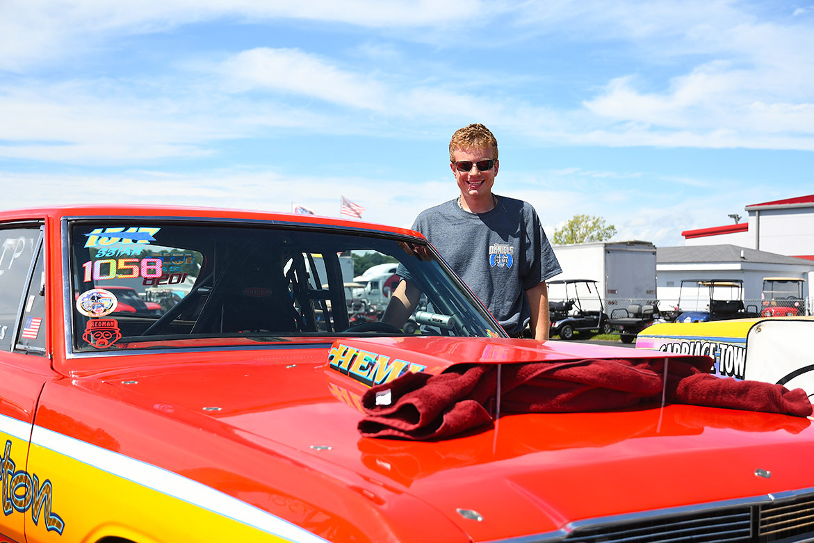 man standing next to his dodge vehicle