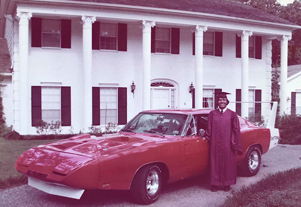 man standing next to a dodge vehicle