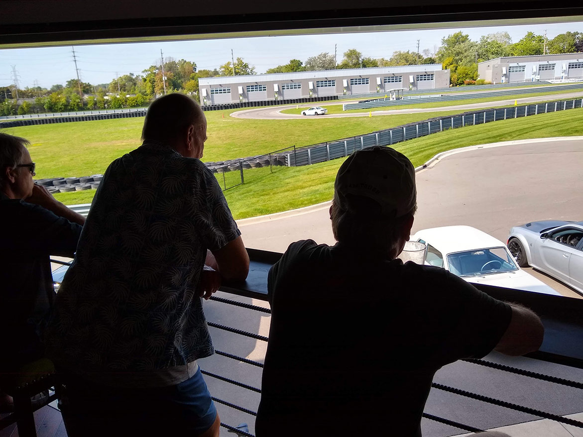 men watching cars on the concourse