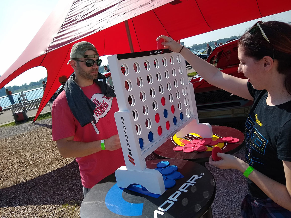 man and woman playing an oversized connect four game