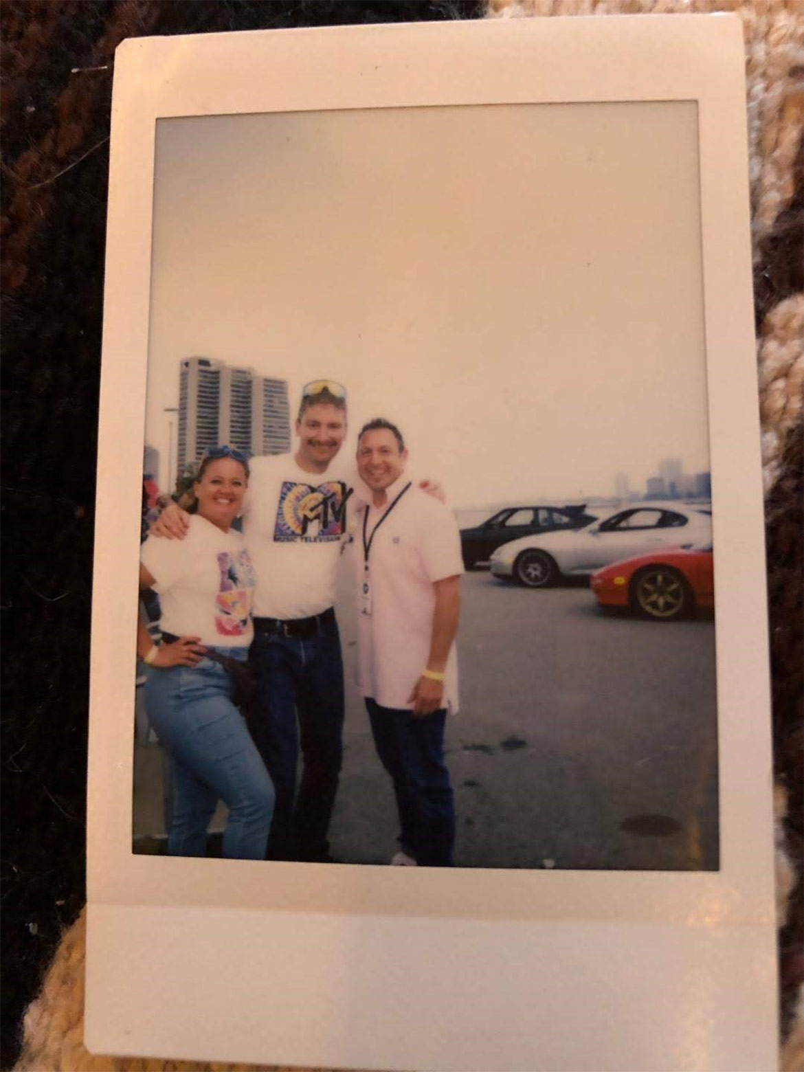 photo of a poloroid of two men and one woman