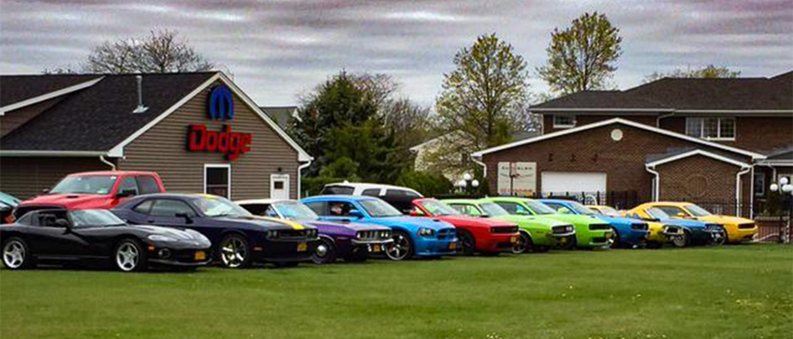 many dodge vehicles parked outside a mopar barn