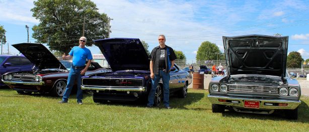 men standing with dodge vehicles