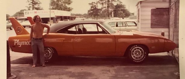 man standing next to a dodge vehicle