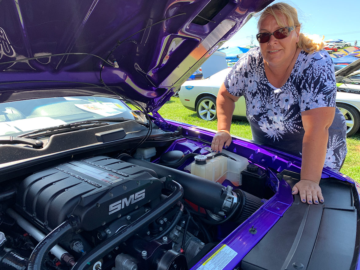 woman showing the engine of her dodge vehicle