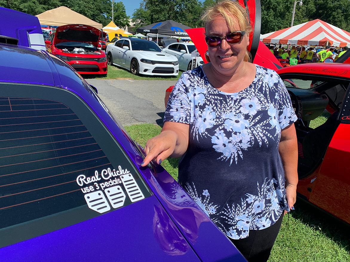 woman pointing at a window decal on her dodge vehicle rear windshield