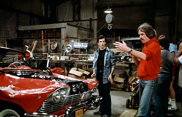 group of men in a garage with a vehicle