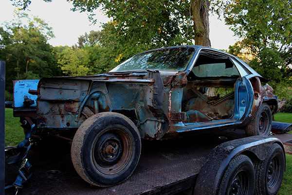 decrepit plymouth vehicle on a trailer bed