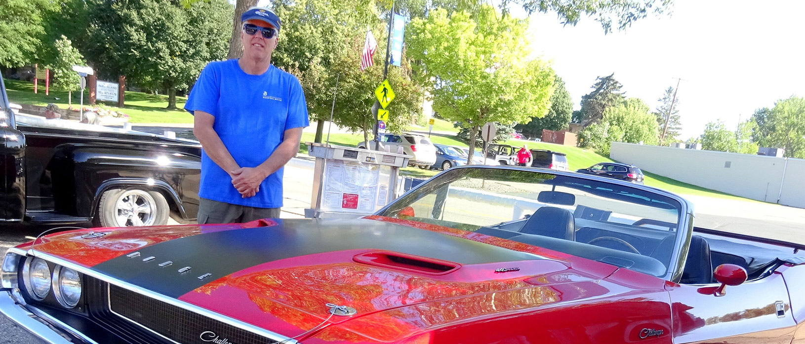 man standing next to his 1970 Dodge Challenger