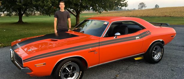 man standing next to his dodge vehicle