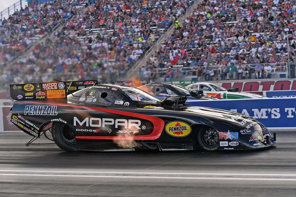 funny cars on the starting line of a drag strip