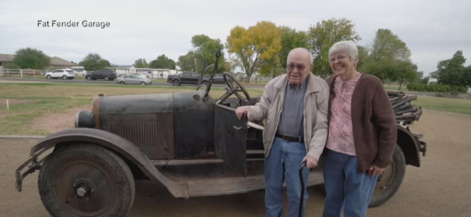 man and woman standing beside historic dodge