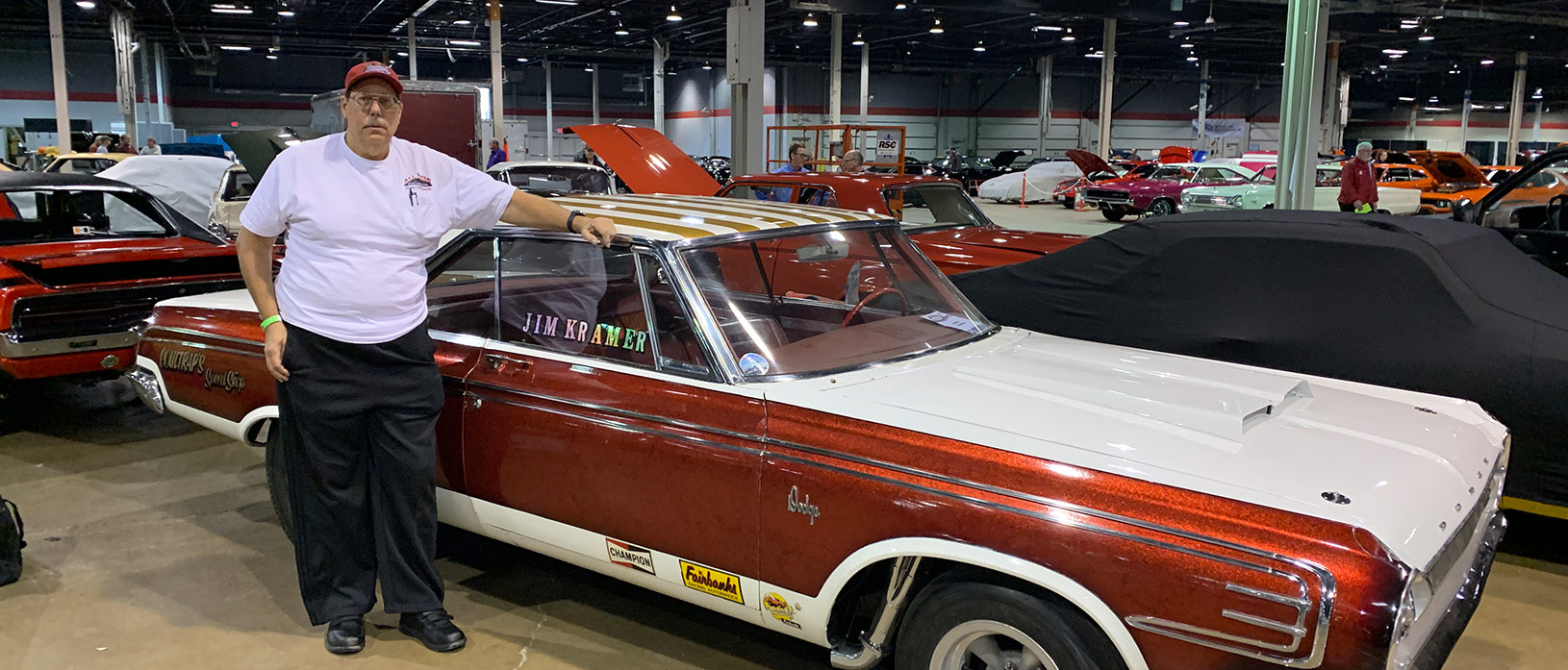 man standing beside historic dodge