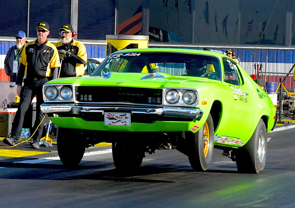 car on two wheels on a drag strip