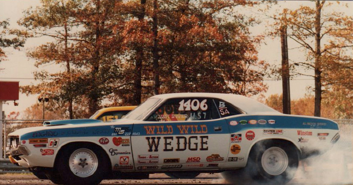 old picture of a vehicle doing a burnout on a drag strip