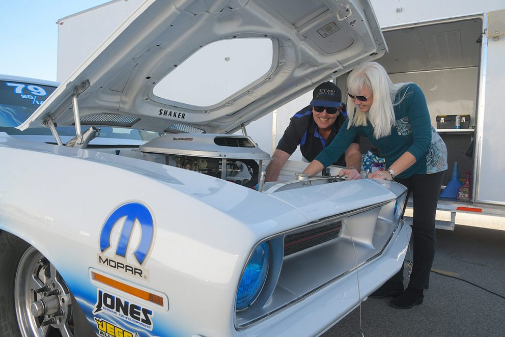 man and woman working on a vehicle