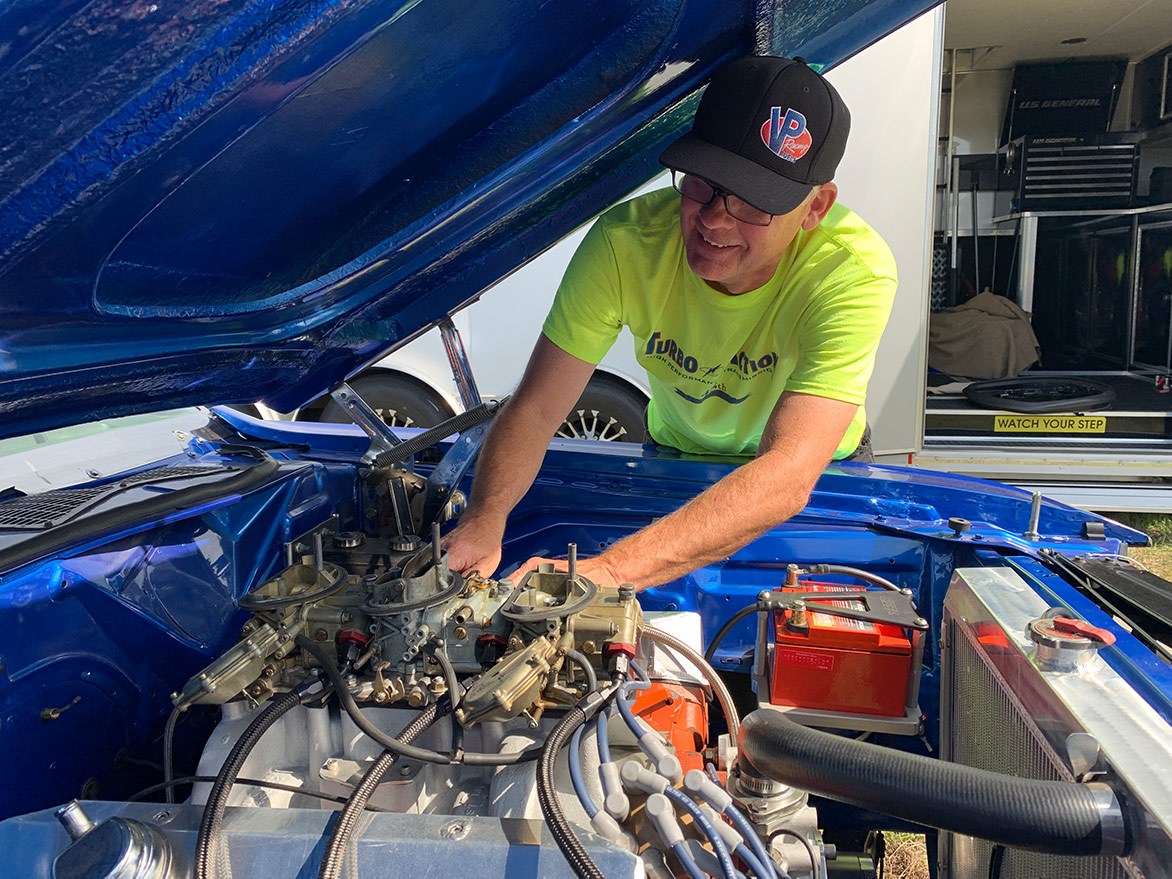 man working on a vehicle engine